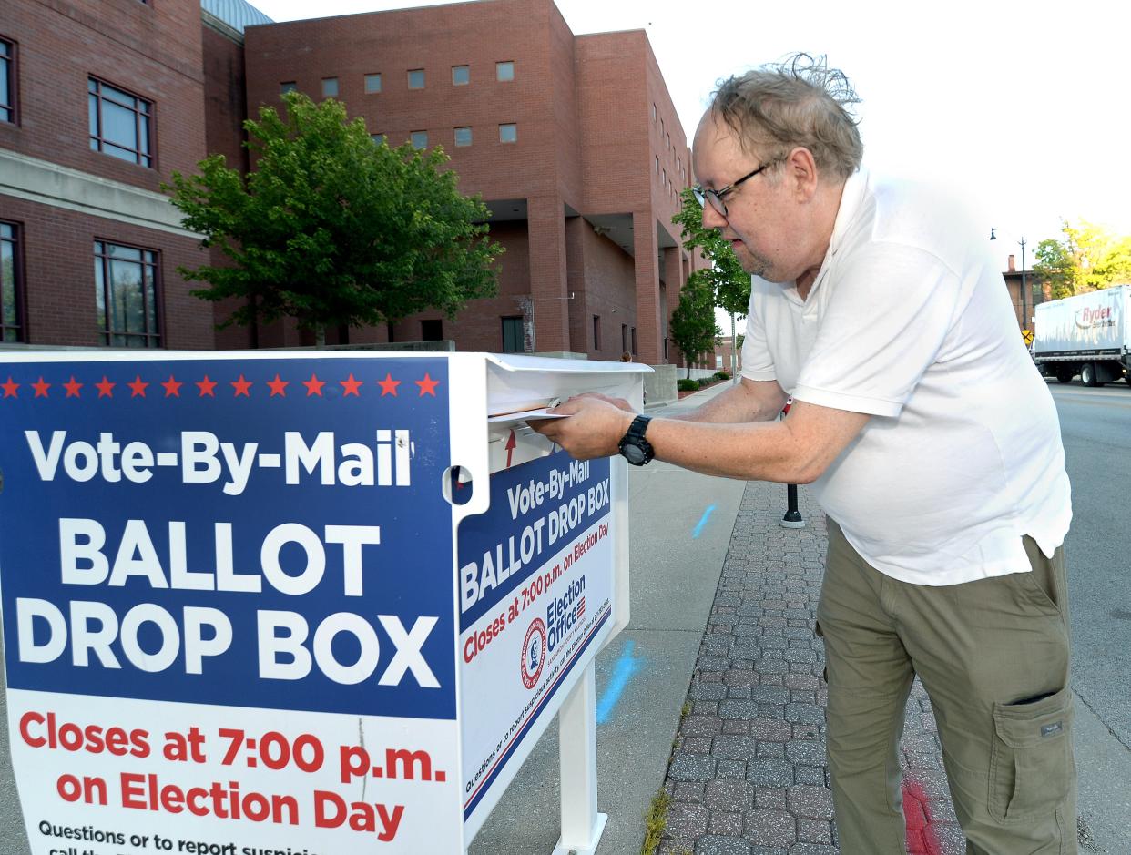 Gene Puschel of Springfield is the last voter to drop a ballet in the dropbox at the County Complex at 6:58 p.m. before the box was closed at 7 p.m. Tuesday.
