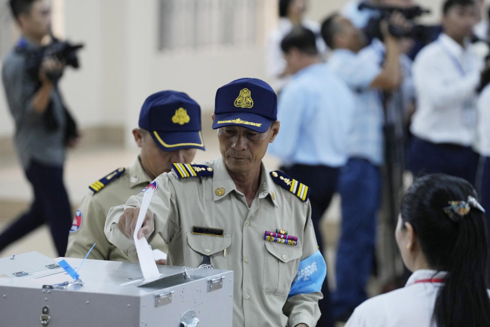 Cambodian police officers cast a ballot for voting at a polling station at Takhmua in Kandal province, southeast Phnom Penh, Cambodia, Sunday, July 23, 2023. Cambodians go to the polls Sunday with incumbent Prime Minister Hun Sen and his party all but assured a landslide victory thanks to the effective suppression and intimidation of any real opposition that critics say has made a farce of democracy in the Southeast Asian nation. (AP Photo/Heng Sinith)