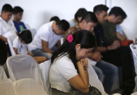 Family members of passengers onboard missing AirAsia flight QZ8501 pray at a waiting area in Juanda International Airport, Surabaya, Indonesia, December 30, 2014. REUTERS/Beawiharta