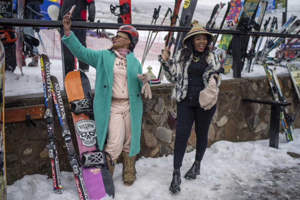 Dos mujeres, una con un sombrero tradicional Basutu, se toman una selfie durante una visita a la estación de esquí Afriski cerca de Butha-Buthe, Lesotho, el 30 de julio de 2022. Afriski en las montañas Maluti es la única estación de esquí en funcionamiento de África al sur de la línea ecuatorial. (AP Foto/Jerome Delay)