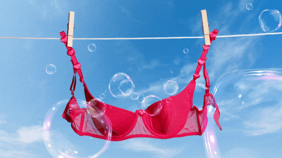 Washed red bra hanging on clothing line with rising bubbles.
