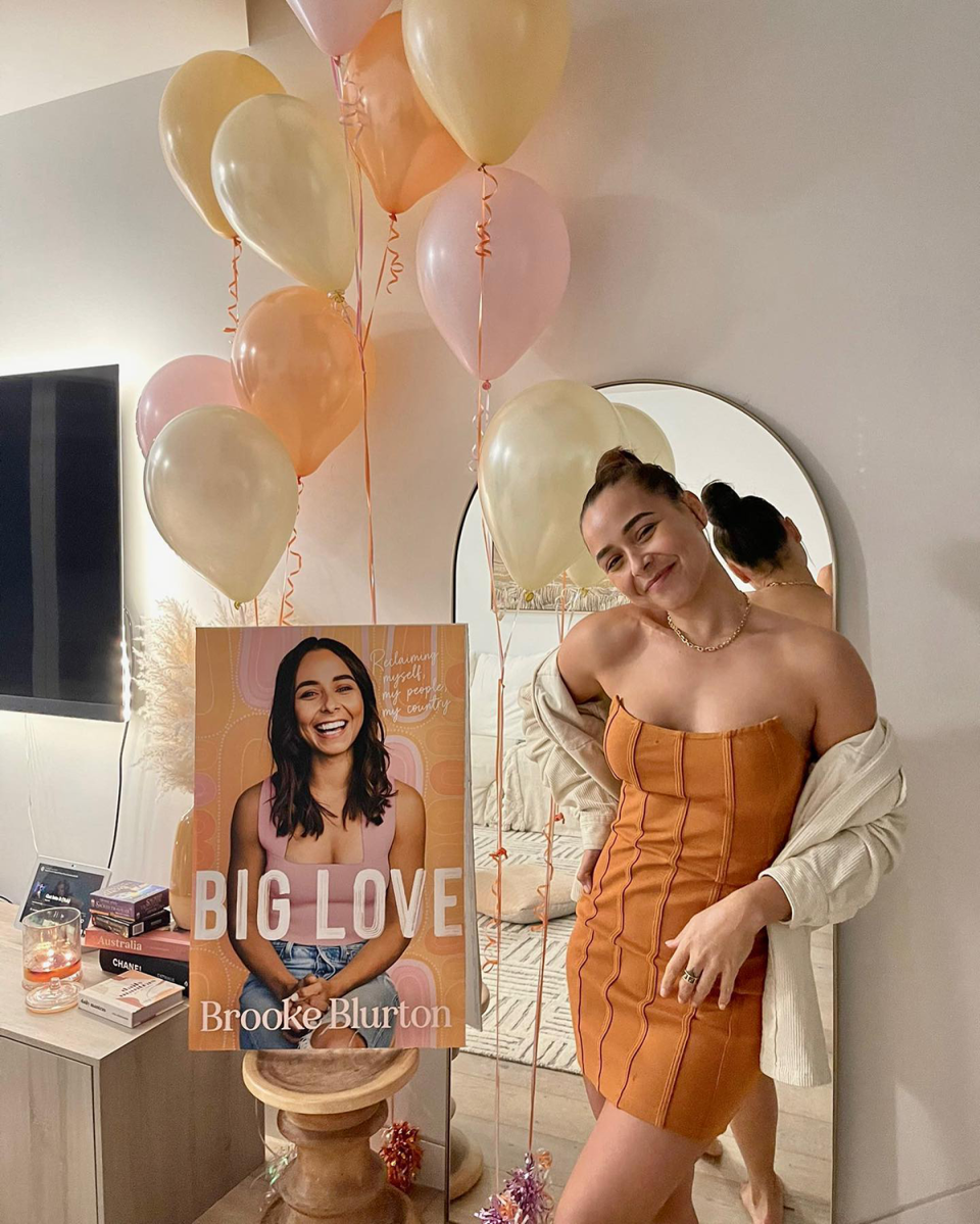 Brooke Blurton posing next to her memoir Big Love.