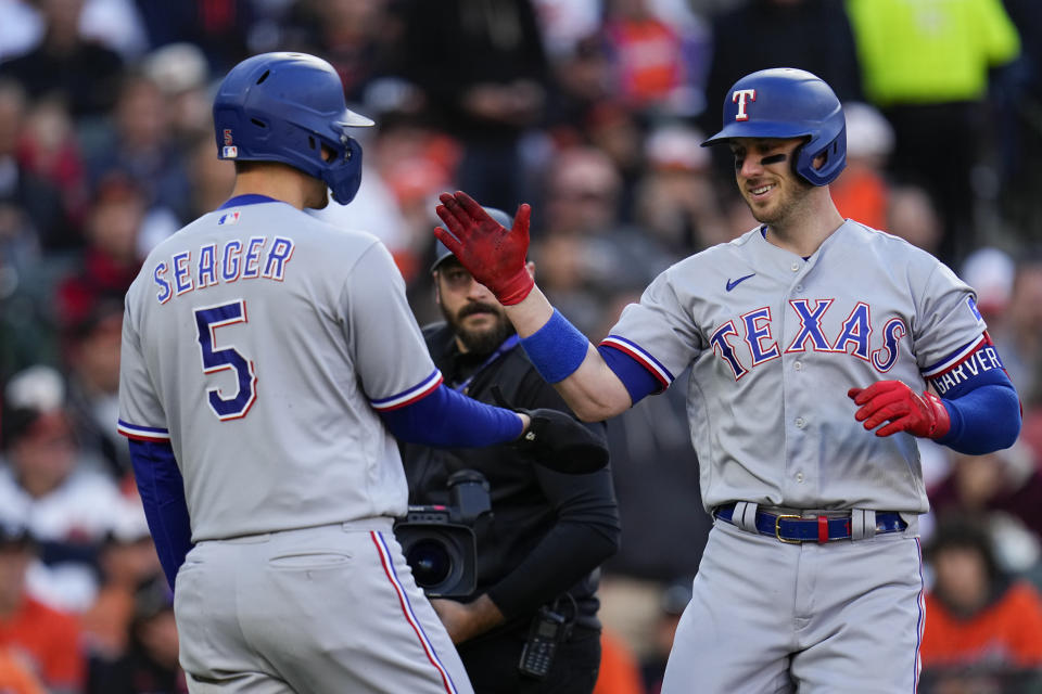 Texas Rangers' Mitch Garver, right, celebrates his grand slam with Corey Seager (5) during the third inning in Game 2 of an American League Division Series baseball game against the Baltimore Orioles, Sunday, Oct. 8, 2023, in Baltimore. (AP Photo/Julio Cortez)