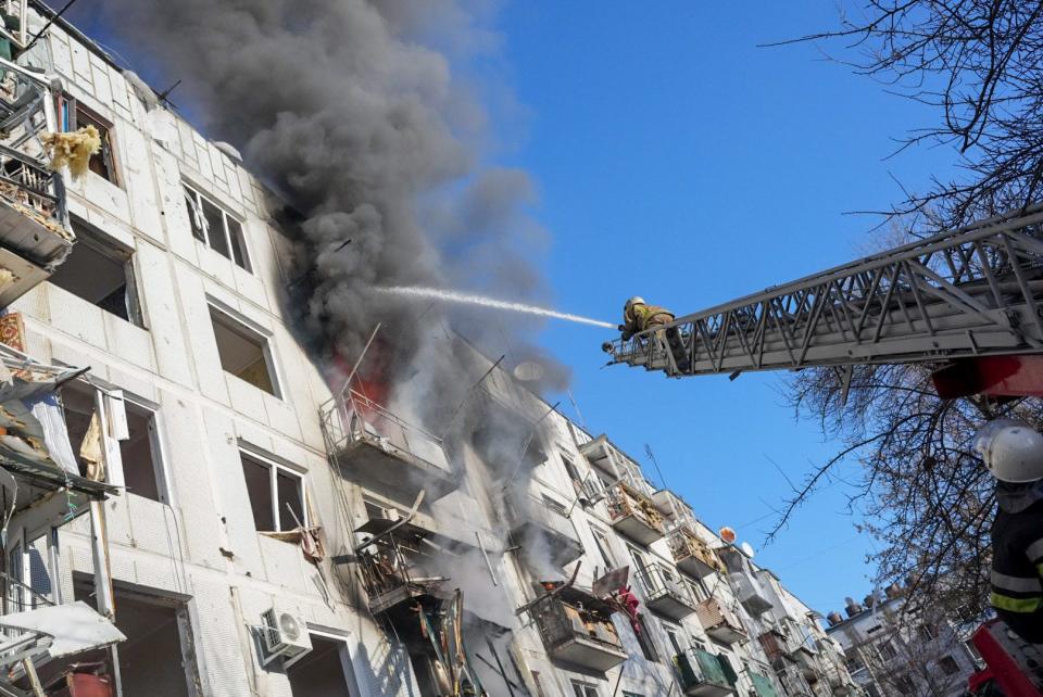 Firefighters try to extinguish a fire in the wake of an airstrike in Chuguiv, Ukraine