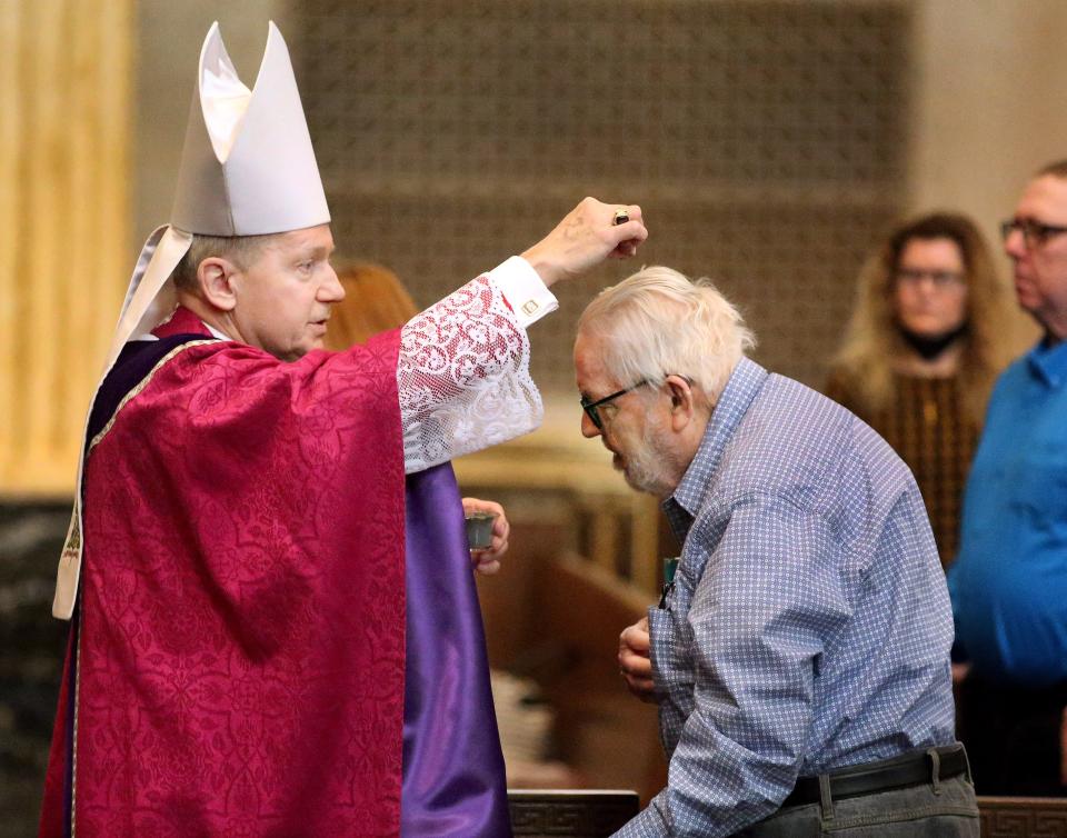 Howard Beagles of Springfield, right, gets ashes sprinkled on the top of his head for Ash Wednesday by Springfield of Illinois Bishop Thomas John Paprocki at the Cathedral of Immaculate Conception March 2, 2022.