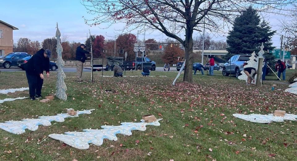 Volunteers set up cutout Christmas trees on Nov. 11 on the southside of New Philadelphia.