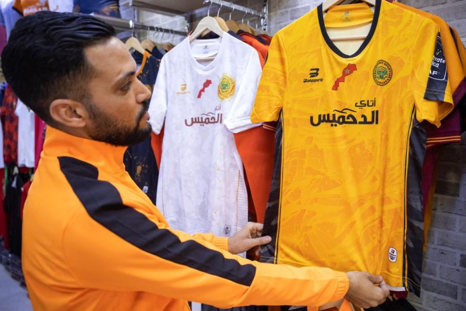 A fan of Morocco's RS Berkane football team checks out the team's shirt at a store in the city of Berkane.