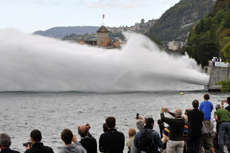 FILE - People watch a huge water jet of 350m length throwing 20,000 liters of water per second into the Geneva Lake, during a functional check of the Forces Motrices Hongrin-Leman hydropower plant in Veytaux, Switzerland, Aug. 29, 2009. Faced with increasing demand for alpine water resources at a time of accelerating glacier melt, policymakers from 8 European countries are meeting in Switzerland to prevent a dispute over diminishing water resources the Alps. (Dominic Favre/Keystone via AP, File)