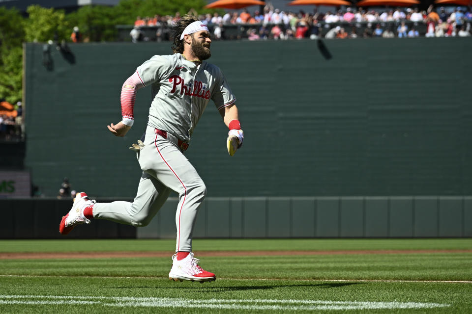 Philadelphia Phillies Bryce Harper runs towards home to score on a double by Alec Bohm during the first inning of a baseball game against the Baltimore Orioles, Saturday, June 15, 2024, in Baltimore. (AP Photo/Nick Wass)