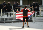 Stephen Chang of Los Angeles protests in front of police officers at Los Angeles Police Department headquarters, Thursday, June 4, 2020, in Los Angeles. Protests continue to be held in U.S. cities over the death of George Floyd, a black man who died after being restrained by Minneapolis police officers on May 25. (AP Photo/Chris Pizzello)