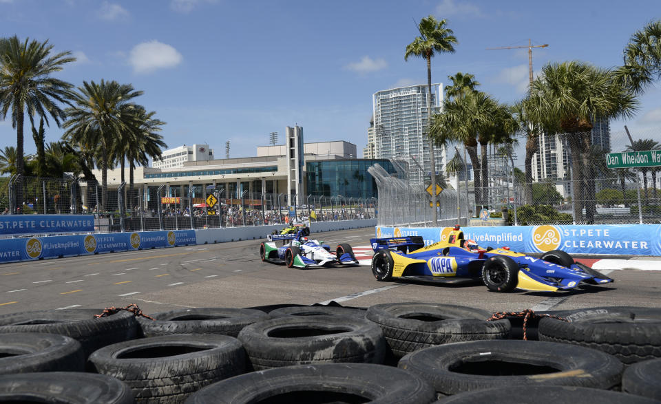 FILE - In this March 11, 2018, file photo, Alexander Rossi (27) and Marco Andretti (98) race through Turn 10 during the IndyCar Firestone Grand Prix of St. Petersburg, in St. Petersburg, Fla. NASCAR and IndyCar have each called off their races this weekend. NASCAR was scheduled to run Sunday at Atlanta Motor Speedway without spectators but said Friday it is calling off this weekend and next week’s race at Homestead-Miami Speedway. IndyCar was scheduled to open its season Sunday on the streets of St. Petersburg, Florida, but suspended it’s season through the end of April. (AP Photo/Jason Behnken, File)