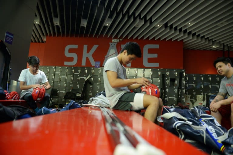 Members of the Philippines men's ice hockey team, dubbed the "Mighty Ducks", prepare their gear prior to a practice session at a mall skating rink in Manila