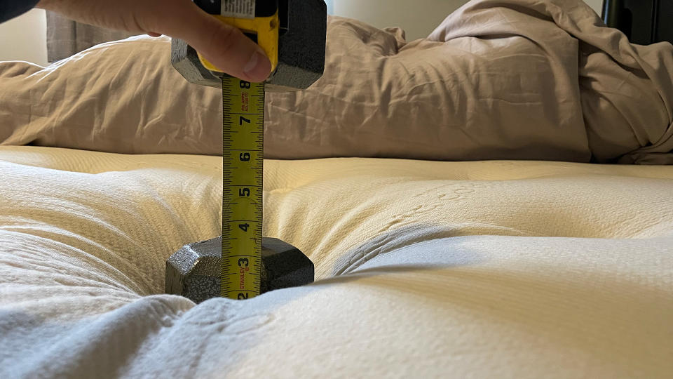 A weight pressing down on the centre of a mattress