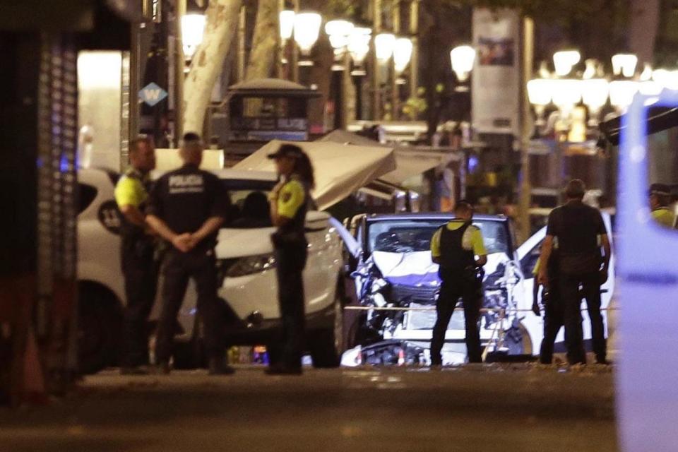 Police officers stand next to the van involved on an attack in La Ramblas in Barcelona. (AP)