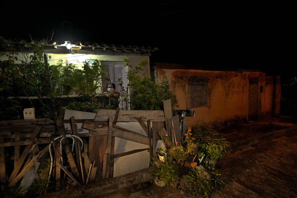 Natalicia Goncalves, a 77-year-old retired teacher, stand in front of her home in the in the Pinheiro neighborhood of Maceio, Alagoas state, Brazil, Tuesday, March 8, 2022. Goncalves is the last remaining resident on her street after the others have been forced to leave because of the threat of ground subsidence and geological problems caused by the Braskem mine, that has caused the evacuation of more than 55 thousand people. (AP Photo/Eraldo Peres)