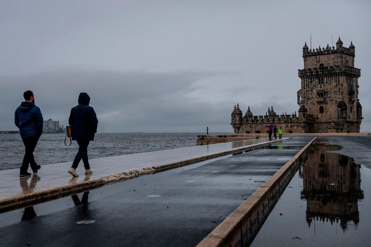 People walk along the Tagus River in Belem, Portugal, during storm Barbara on 20 October, 2020.  (AFP via Getty Images)