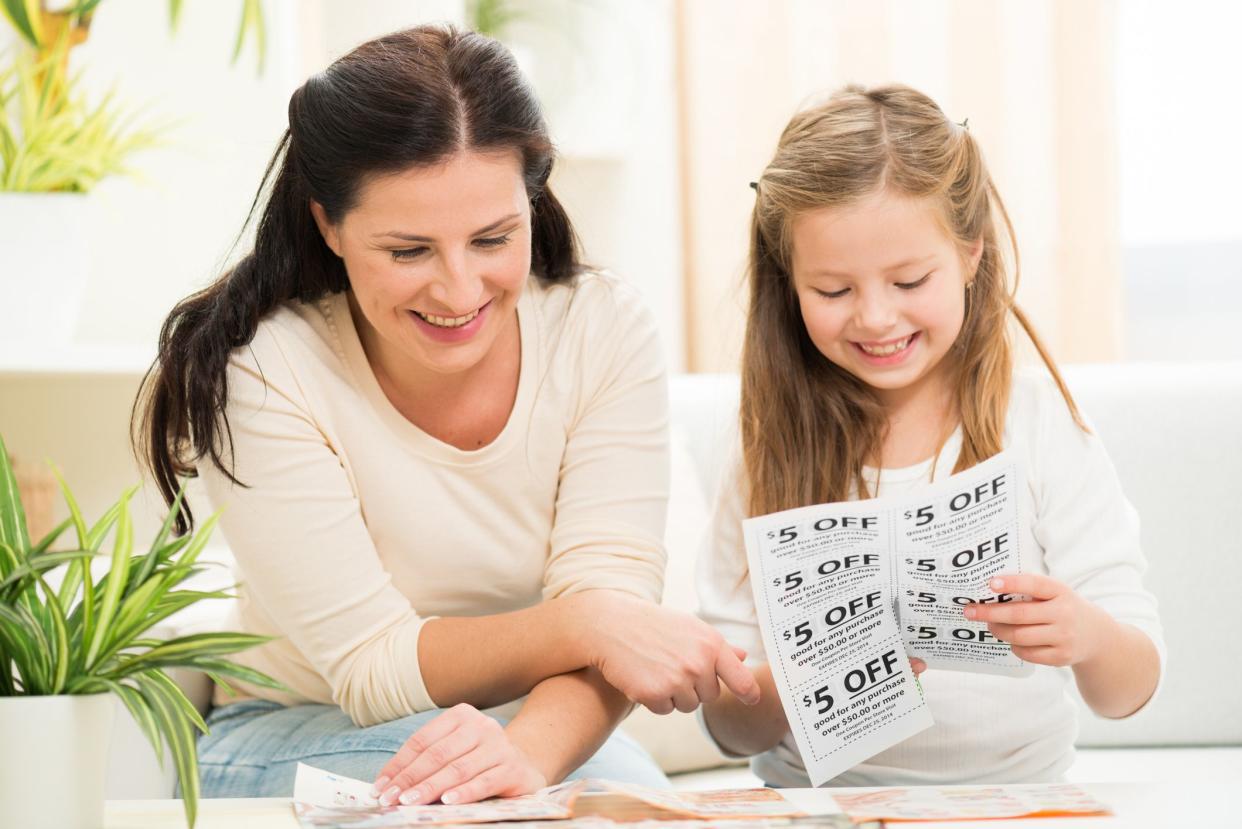 Mother and daughter cut coupons for shopping with discount