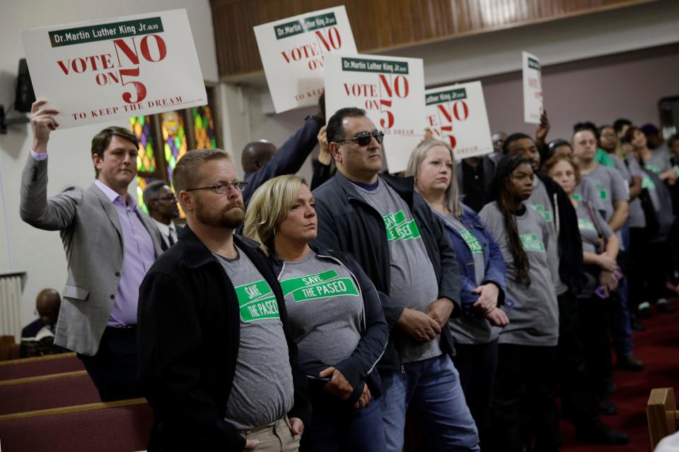 People wearing "Save The Paseo" shirts stand among attendees at a rally to keep a street named in honor of Dr. Martin Luther King Jr. at Paseo Baptist Church in Kansas City, Missouri, Nov. 3, 2019.