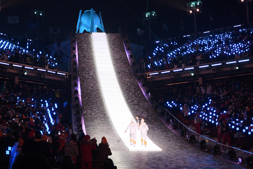 <p>Torchbearers carry the Olympic flame to its cauldron during the Opening Ceremony of the PyeongChang 2018 Winter Olympic Games at PyeongChang Olympic Stadium on February 9, 2018 in Pyeongchang-gun, South Korea. (Photo by Quinn Rooney/Getty Images) </p>