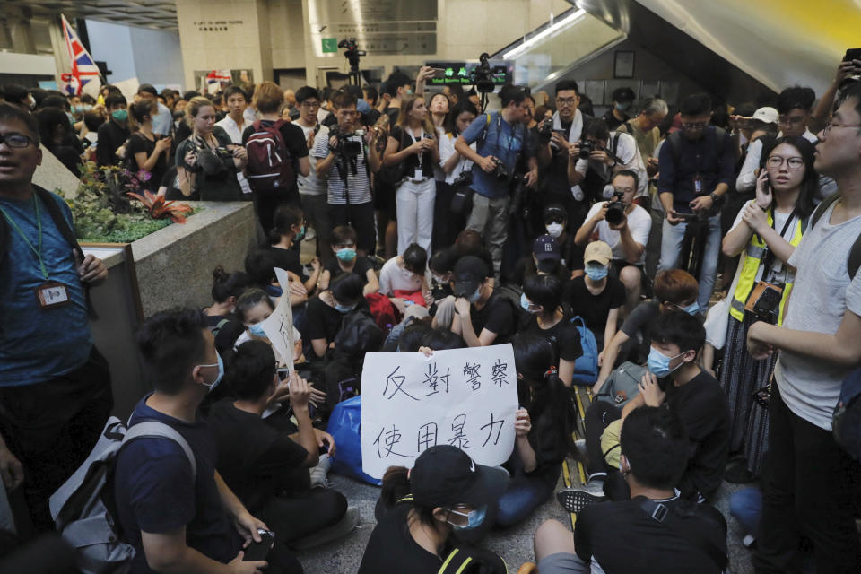 Protesters hold a card which reads "Against Police Using Violence" in the lobby of the Hong Kong Revenue Tower in Hong Kong on Monday, June 24, 2019. Hong Kong has been rocked by major protests for the past two weeks over legislative proposals that many view as eroding the territory's judicial independence and, more broadly, as a sign of Chinese government efforts to chip away at the city's freedoms. (AP Photo/Kin Cheung)