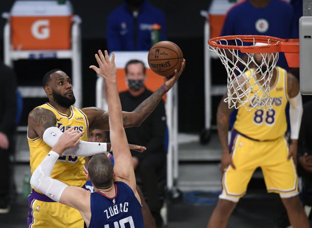 LeBron James #23 of the Los Angeles Lakers scores on a layup over Ivica Zubac #40 of the LA Clippers during a 116-109 LA Clippers win in the season opening game.