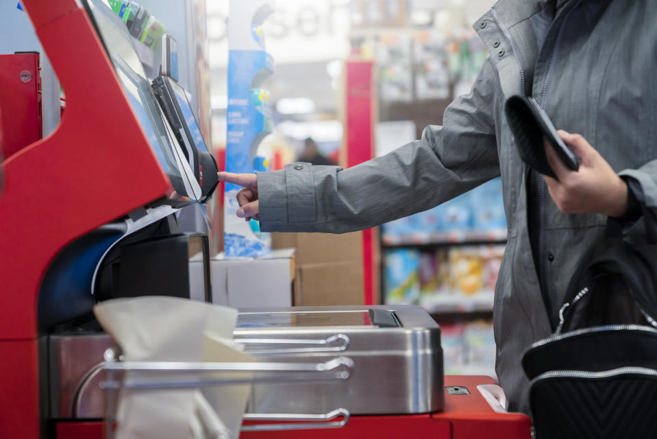 Customer uses self check out at grocery store. Despite credit card interest rates hovering above 20%, more Americans are relying on plastic to offset growing costs of food, Quicken Inc. found. (Credit: Getty Creative) 