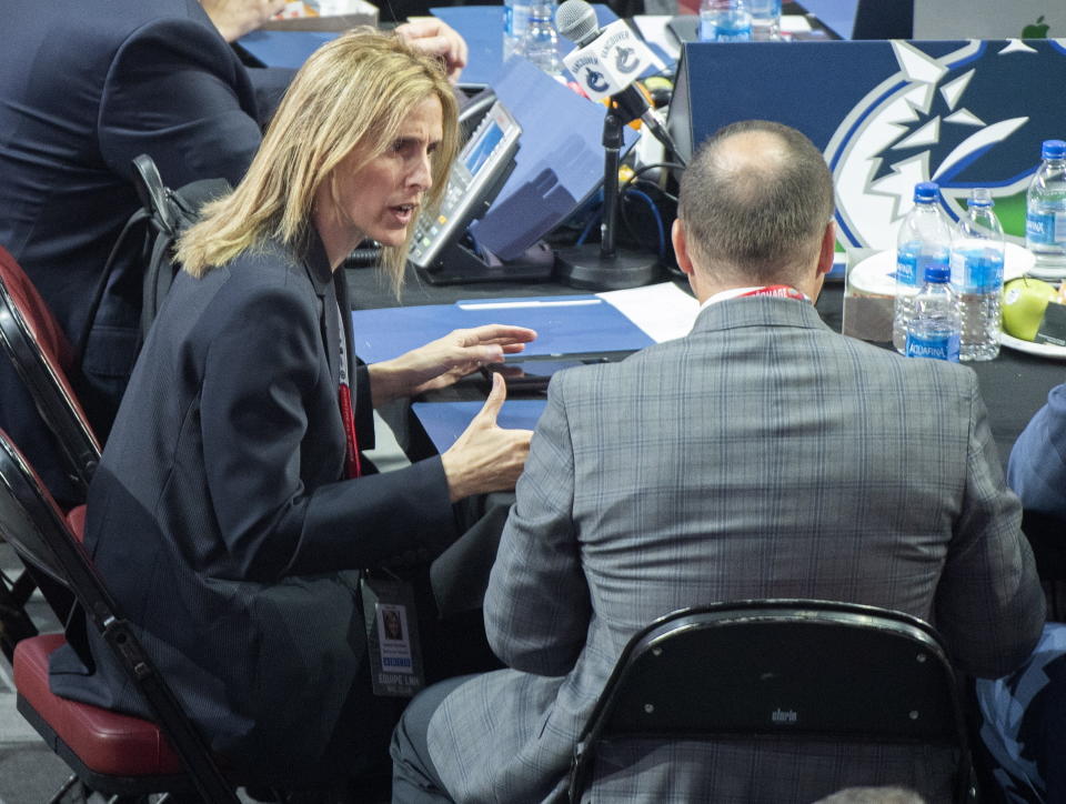 FILE - Vancouver Canucks hockey team assistant general manager Cammi Granato, left, takes part in the first round of the NHL draft in Montreal, Thursday, July 7, 2022. At the start of 2022, there were no women serving as assistant general managers in the NHL. Now there are five. Granato hopes this becomes a normal occurrence, and coaching is the next frontier for women in hockey. (Graham Hughes/The Canadian Press via AP, File)