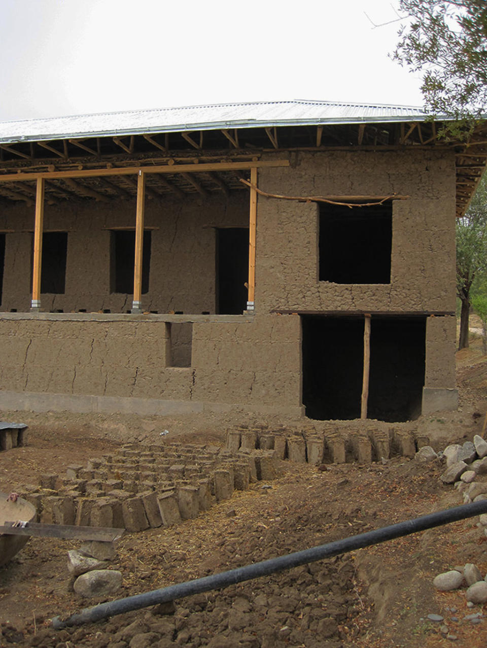 A modern mud-brick house under construction in Uzbekistan in 2010. The mud bricks out front are drying in the sun. <cite>Ruth Shahack-Gross</cite>