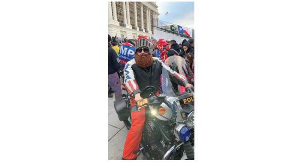 Brandon Fellows appears in a photograph atop a police motorcycle during the Capitol riot on Jan. 6, 2021.