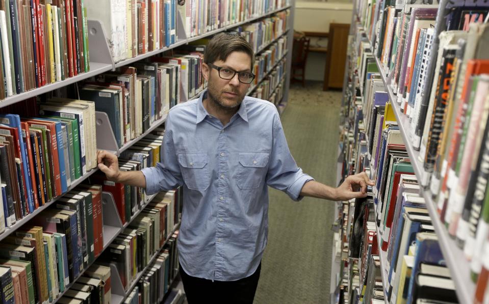 Josh Kun, the curator who organized a collection of music themed around Loa Angeles poses for a picture at the main branch of the Los Angeles Public Library Friday, June 21, 2013 in Los Angeles. Kun, a USC professor and some of his students, have digitized them, put a cross-section of nearly 200 into a colorful coffee-table book and even persuaded the LA fusion group Ozomatli to perform many at a concert later this summer. (AP Photo/Chris Carlson)