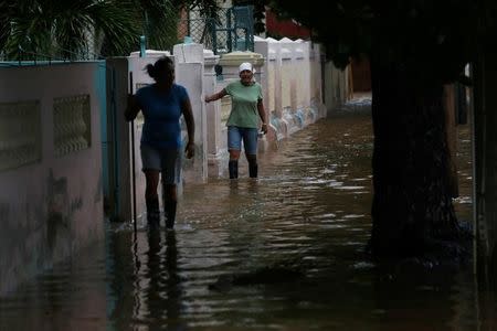 Women wade through a flooded street as Hurricane Irma turns toward the Florida Keys on Saturday, in Havana, Cuba September 9, 2017. REUTERS/Stringer