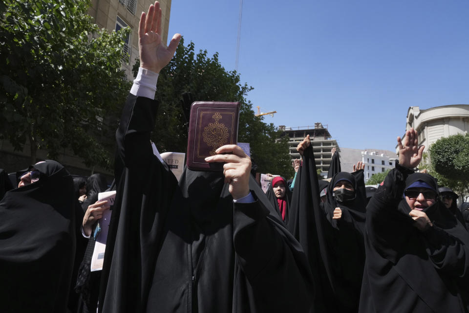 Iranian demonstrators chant slogans as one of them holds up a copy of Quran, Islam's holy book, during a protest of the burning of a Quran in Sweden, in front of the Swedish Embassy in Tehran, Iran, Friday, June 30, 2023. On Wednesday, a man who identified himself in Swedish media as a refugee from Iraq burned a Quran outside a mosque in central Stockholm. (AP Photo/Vahid Salemi)