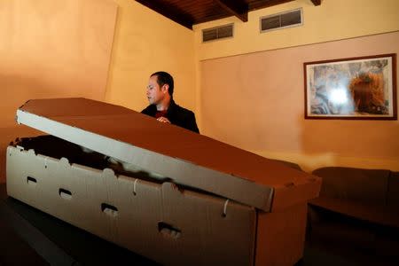 Alejandro Blanchard assembles a cardboard coffin at a mortuary in Valencia, in the state of Carabobo, Venezuela August 25, 2016. Picture taken August 25, 2016. REUTERS/Marco Bello