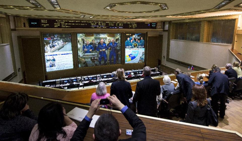 A view from the balcony of the Russian Mission Control Center shows live television of the Expedition 39 crew members gathered together on the International Space Station a few hours after the Soyuz TMA-12M spacecraft docked on Friday, March 28, 2014, in Korolev, Russia. Expedition 39's arrival to the International Space Station comes two days after they launched from the Baikonur Cosmodrome in Kazakhstan. (AP Photo/NASA, Joel Kowsky)