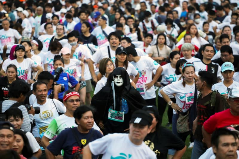 A runner wearing a mask attends a "Run Against Dictatorship" event at a public park in Bangkok