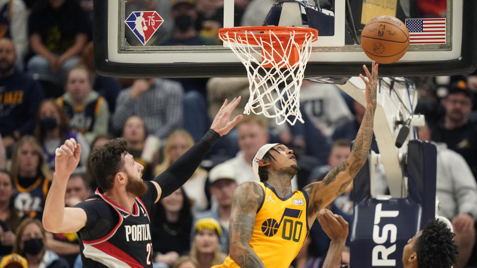 Utah Jazz guard Jordan Clarkson (00) goes to the basket as Portland Trail Blazers center Jusuf Nurkic (27) defends in the first half during an NBA basketball game Monday, Nov. 29, 2021, in Salt Lake City. (AP Photo/Rick Bowmer)