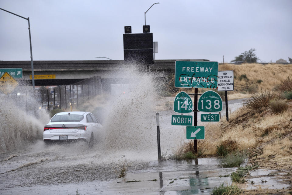 Un vehículo recorre un camino inundado durante el paso de la tormenta tropical Hilary, el domingo 20 de agosto de 2023, en Palmdale, California. (AP Foto/Richard Vogel)