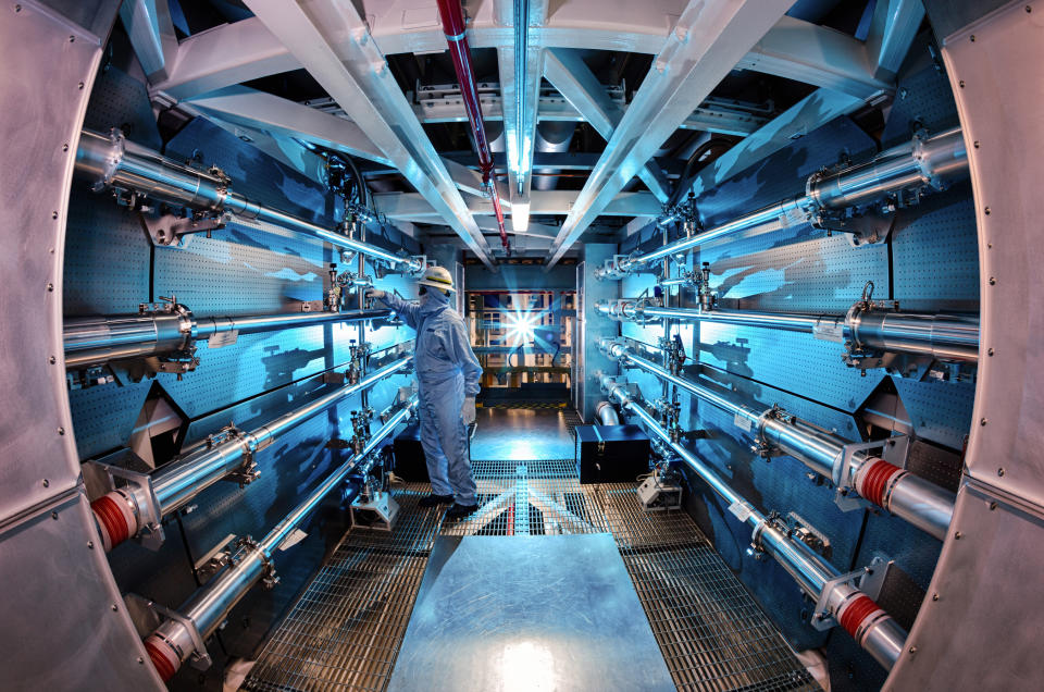 A technician reviews an optic inside the preamplifier support structure at the Livermore lab