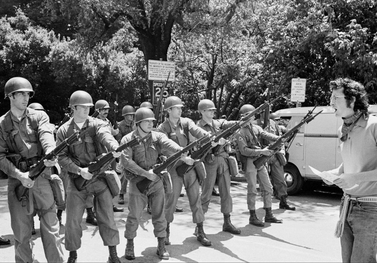 A lone demonstrator argues with National Guard troops.