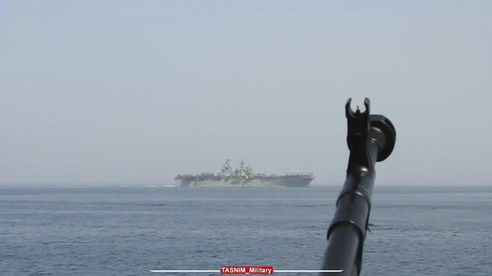 In this image provided by the Iranian Revolutionary Guard via Tasnim News Agency on Sunday, Aug. 20, 2023, a machine gun's muzzle of a Revolutionary Guard speedboat is seen as the boat moves near USS Bataan at the Strait of Hormuz, in the mouth of the Persian Gulf. (Iranian Revolutionary Guard/Tasnim News Agency via AP)