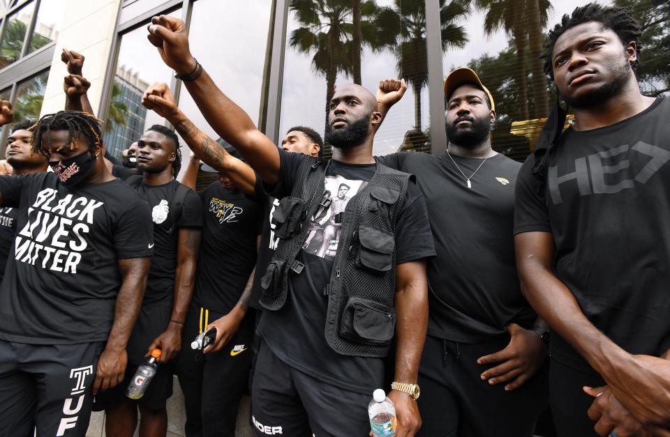 Jacksonville Jaguars running back Leonard Fournette, center, stands with teammates during a rally on Tuesday at Hemming Park in the city's downtown.
