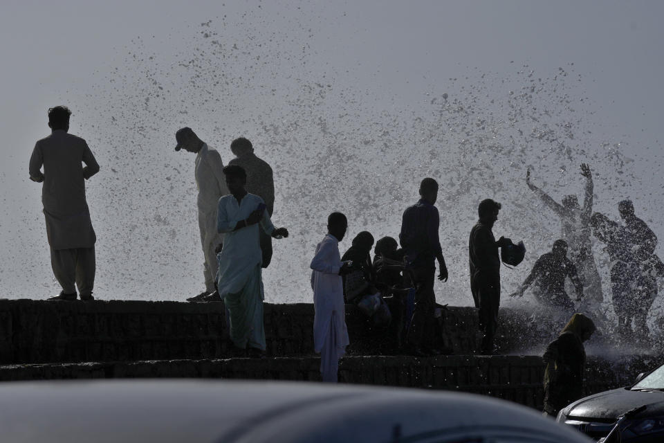 People enjoy high tide waves on the Arabian Sea, in Karachi, Pakistan, Sunday, June 11, 2023. Pakistani Prime Minister Shehbaz Sharif ordered officials to put in place emergency measures in advance of the approaching Cyclone Biparjoy in the Arabian Sea. The "severe and intense" cyclone with wind speeds of 150 kilometers per hour (93 miles per hour) was on a course toward the country's south, Pakistan's disaster management agency said. (AP Photo/Fareed Khan)