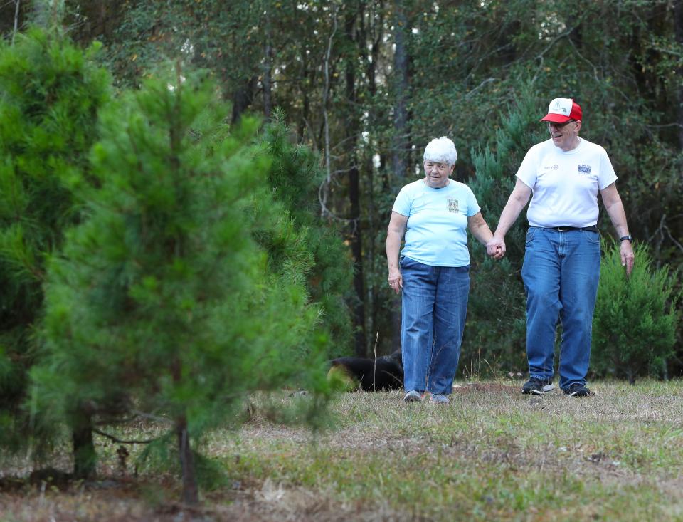 Cathryn and John Gregory, owners of Unicorn Hill Christmas Tree Farm, are shown walking through the main field in December 2021. After thousands of trees sold and a lifetime of memories made, the Gregorys are closing down the farm after this holiday season.