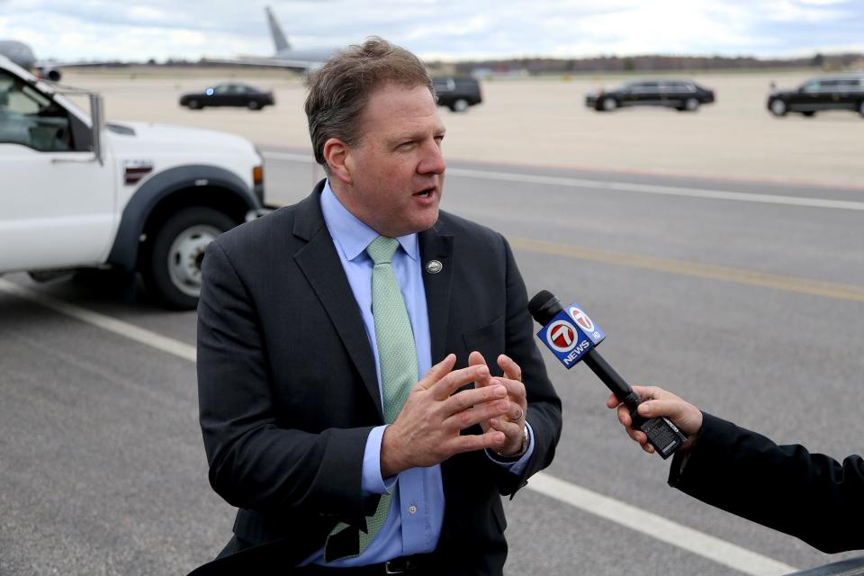 Gov. Chris Sununu speaks to reporters after President Joe Biden arrives with Air Force One at Portsmouth International Airport at Pease on Tuesday, April 19, 2022.