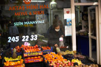 A woman picks up tomatoes in a food shop in Istanbul, Turkey, Thursday, Dec. 2, 2021. Turkey’s beleaguered currency has been plunging to all-time lows against the U.S. dollar and the euro in recent months as President Recep Tayyip Erdogan presses ahead with a widely criticized effort to cut interest rates despite surging consumer prices. (AP Photo/Francisco Seco)