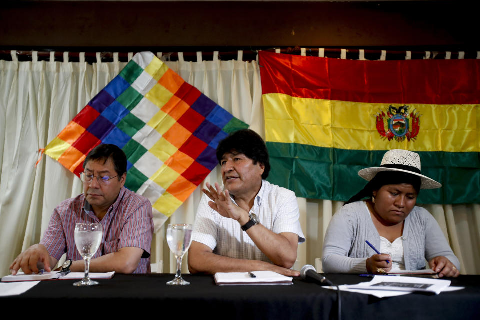 Bolivia's former President Evo Morales speaks to members of his political party, the Movement Towards Socialism Party (MAS), next to the party's presidential candidate Luis Arce, left, and the party's Secretary of International Relations Juanita Ancieta, in Buenos Aires, Argentina, Monday, Feb. 17, 2020. Bolivia will hold elections on May 3. (AP Photo/Natacha Pisarenko)