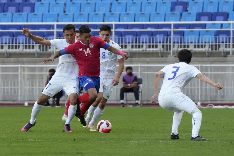 El futbolista costarricense Orlando Galo (centro) pelea por un balón con el uzbeko Otabek Shukurov (izquierda), durante un partido amistoso en Suwon, Corea del Sur, el 27 de septiembre de 2022. (AP Foto/Ahn Young-joon)