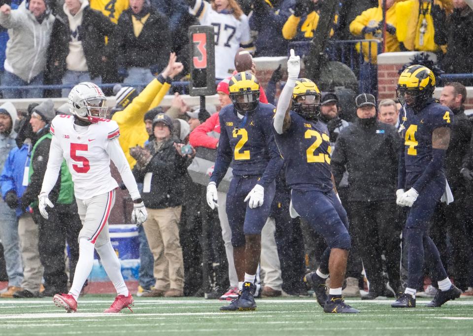 Michigan's Vincent Gray (4), Michael Barrett (23) and Brad Hawkins (2) celebrate after breaking up a pass intended for Ohio State's Garrett Wilson.