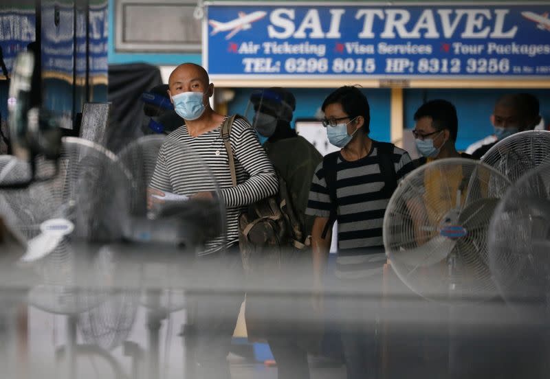 Migrant workers board a bus to leave for a government quarantine facility after workers were tested positive for the coronavirus disease (COVID-19) at Westlite Woodlands dormitory in Singapore