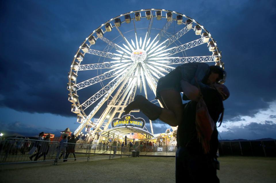 A couple pose for a photo in front of the large ferris wheel  at the Stagecoach Country Music Festival in Indio on Saturday.
